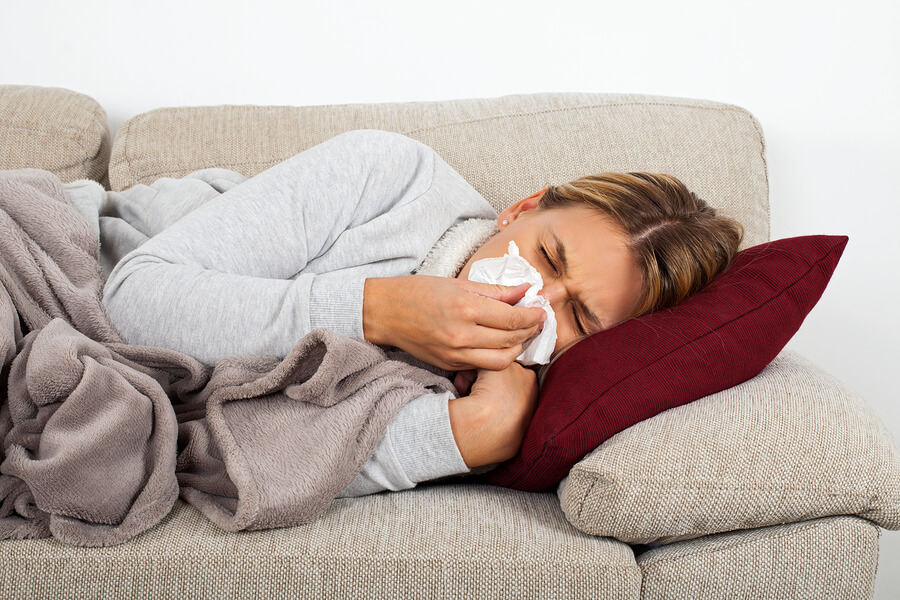 Sick Woman Lying On The Sofa Blowing Her Nose - Sinus Infection