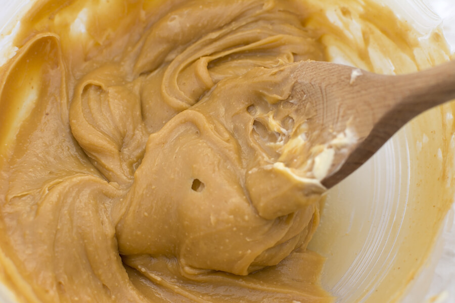 Stir peanut butter wooden spoon smooth